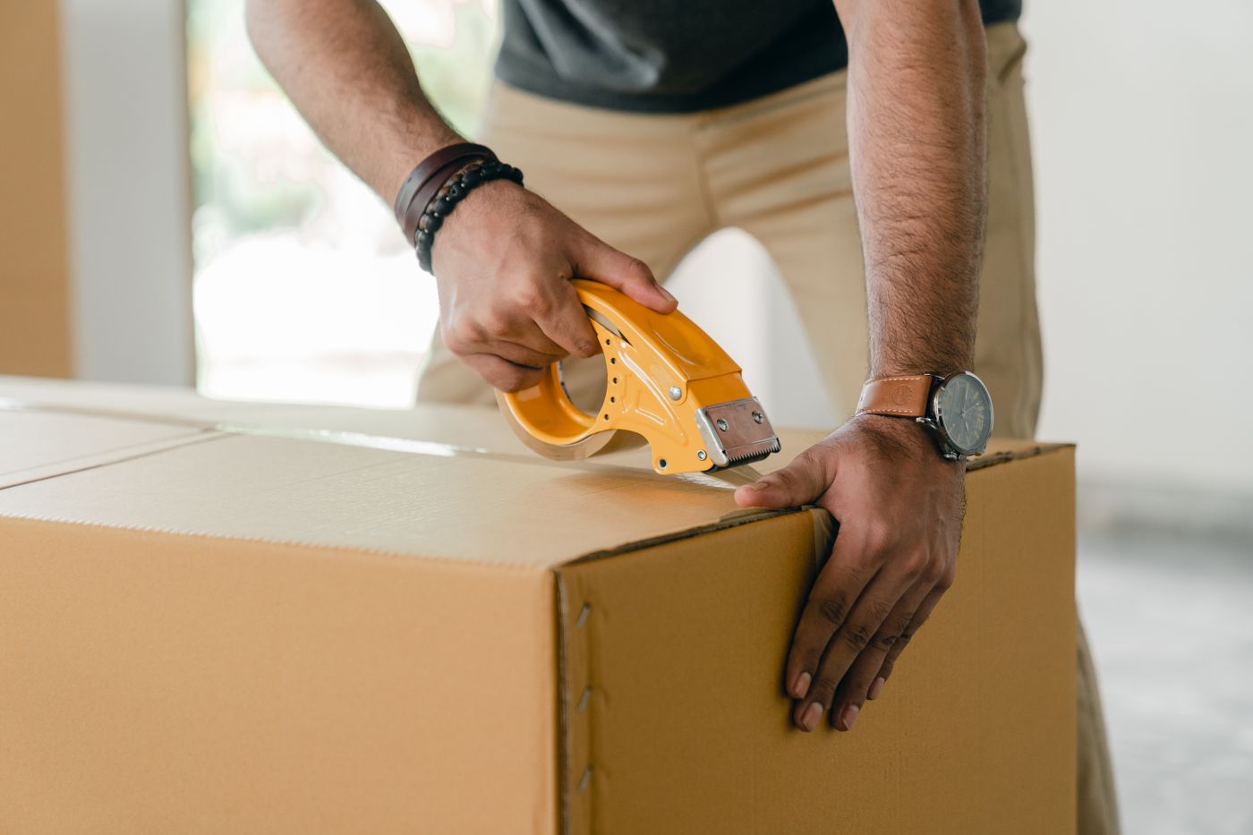 Hands sealing a medication shipment box